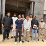 Group of men posing together outside a building at the OBOR event